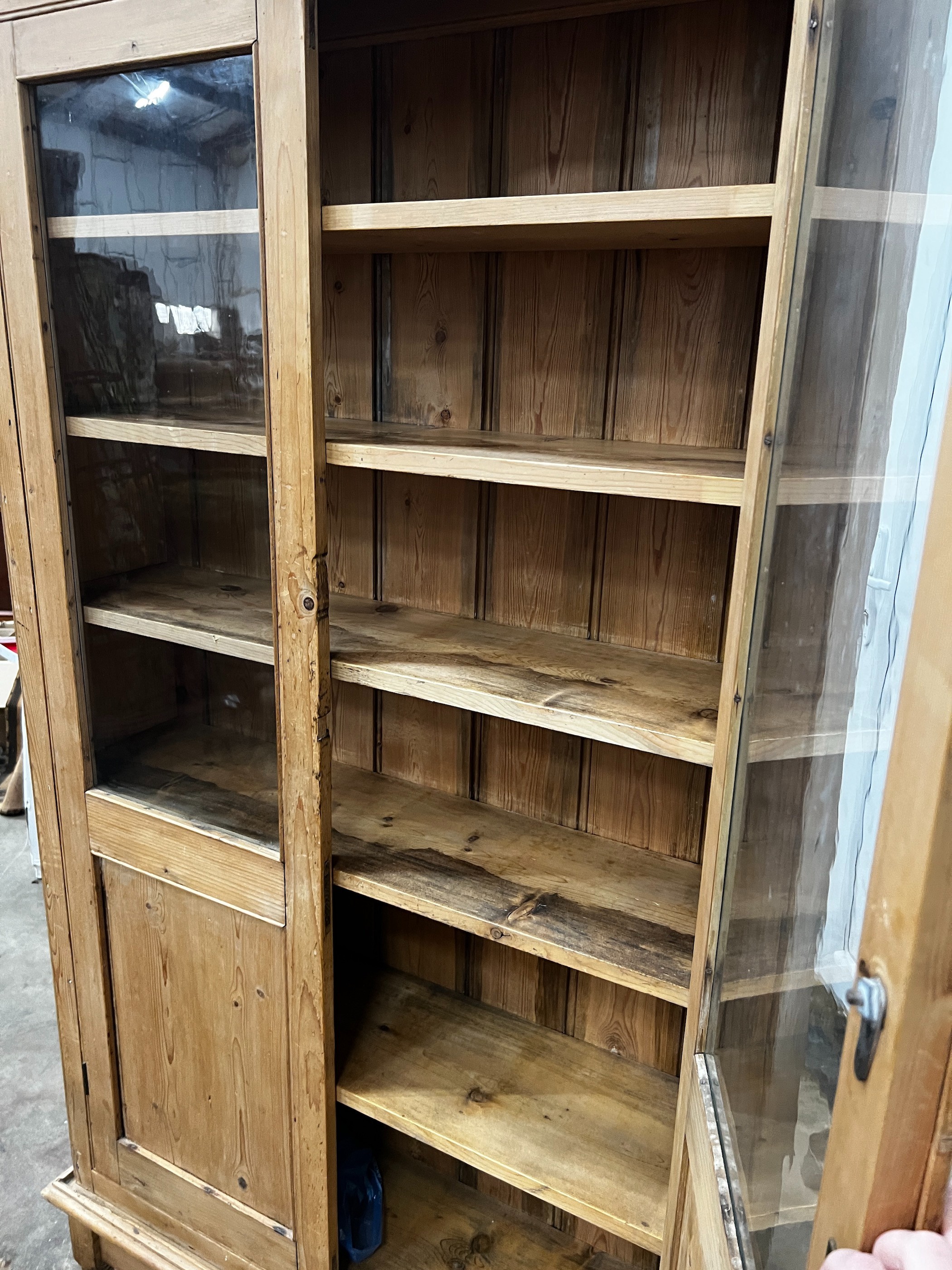 A Victorian glazed pine two door cabinet on stand, width 96cm, depth 27cm, height 182cm
